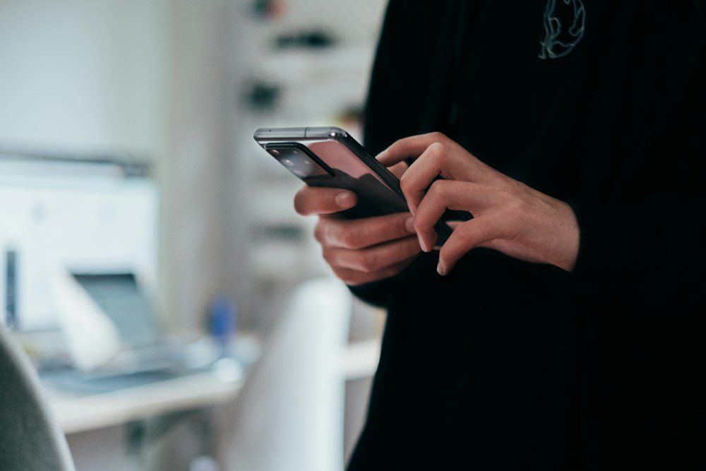 Iemand leest een antwoord op zijn telefoon